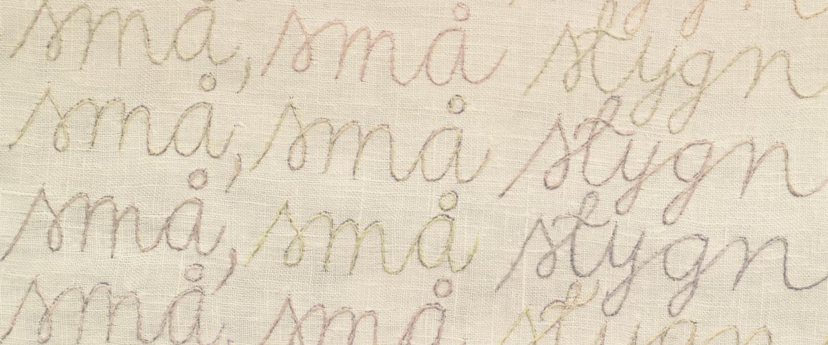 Bilden visar en broderad text av Barbro Eriksson där det står små små stygn i skrivstil.