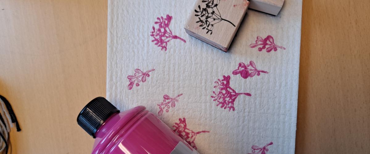 Disktrasa dekorerad med rosa stämplade blommor samt stämplar av trä