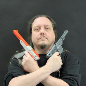 Fotografi av Peo Berglund som håller i två spelpistoler
