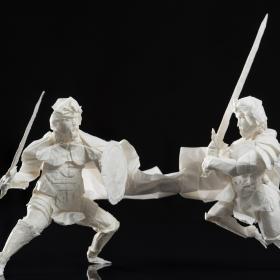 visar två origami figurer med svärd och sköld