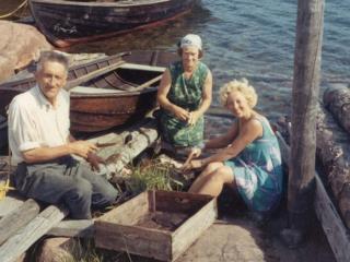 Volmar och Elin Karlsson rensar flundror tillsammans med en sommargäst 1969 (Foto: Ålands landskapsarkiv)