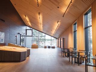Interiör Bomarsunds besökscenter, aulan med en modell till höger. Till vänster vägg med fönster. Rakt fram fönstervägg med montern. I montern finns en fartygsmodell.