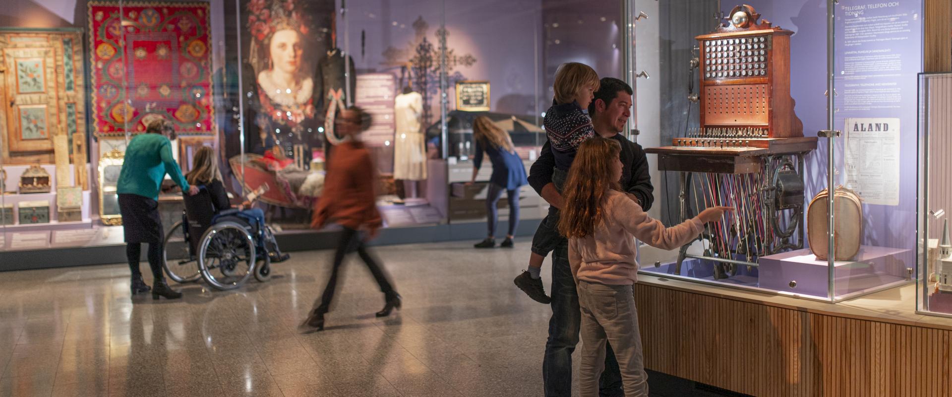 Bilden visar personer som tittar på museiföremål