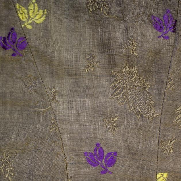 detaljbild på bruna tyget med lila och gula blommor