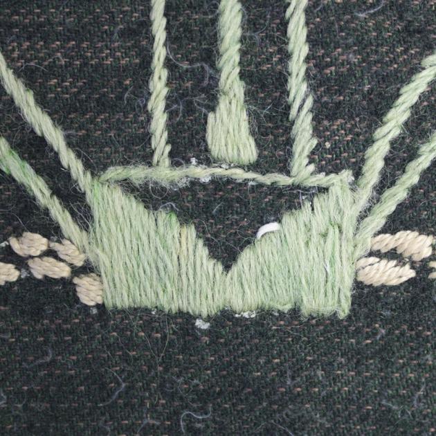 detalj på broderiet i grönt och ljusgult