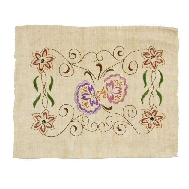 beige kudde broderad med stiliserade blommor