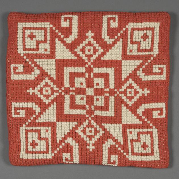 kudde med geometriska mönster i rött och vitt