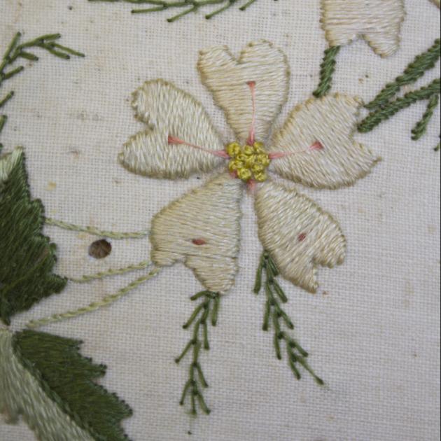 detalj på broderad vit blomma