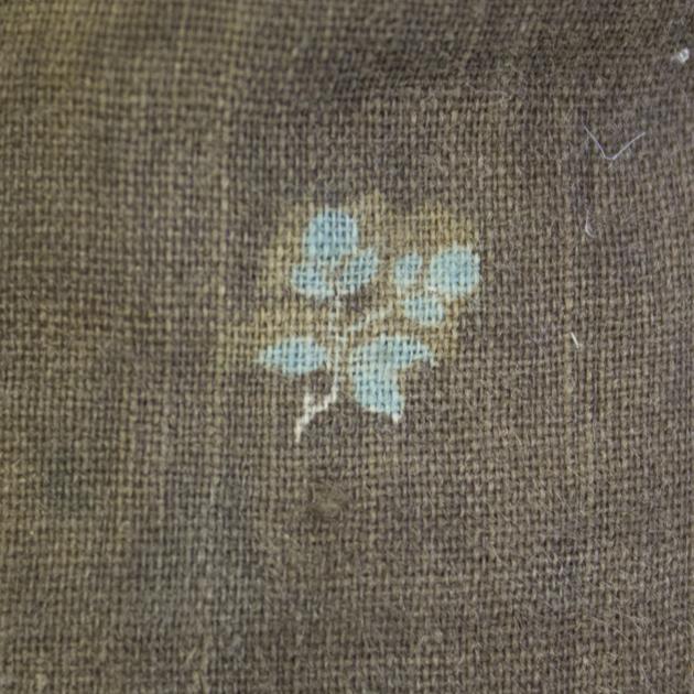 detaljbild på bruna tyget med tryckt blå blomma