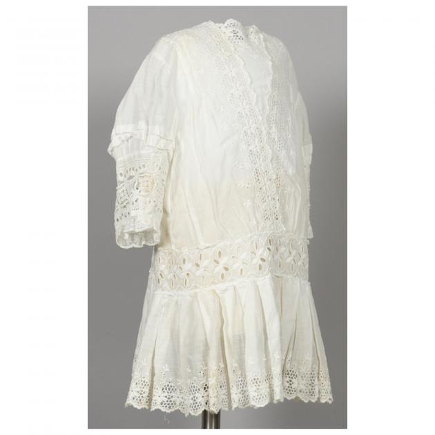 vit klänning med brodyr och spets, snett från sidan