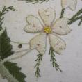 detalj på broderad vit blomma
