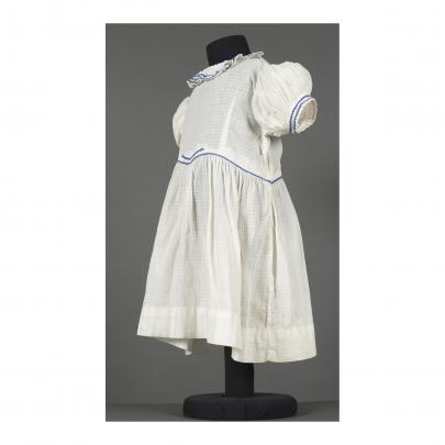 vit klänning med blått dekorband, snett från sidan