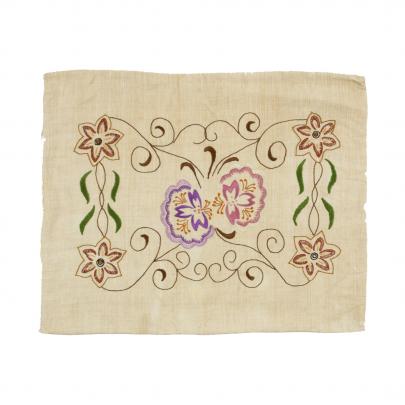 beige kudde broderad med stiliserade blommor