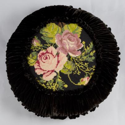 svart kudde i sammet med broderade rosor i mitten