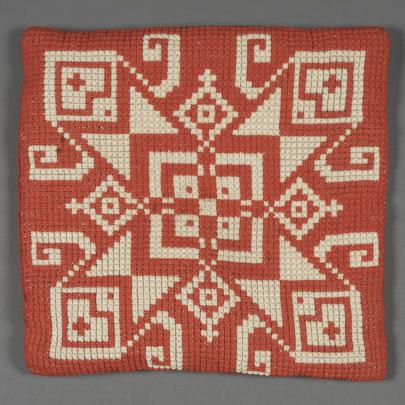 kudde med geometriska mönster i rött och vitt